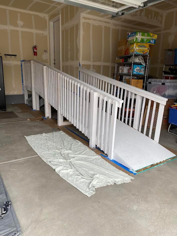 Taped and finished drywall with railing and drop cloths on an AFGH Handyman interior project in progress