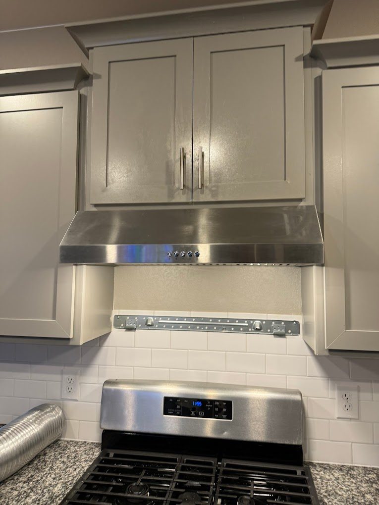 Kitchen cabinets and stainless steel range hood installed by AFGH Handyman