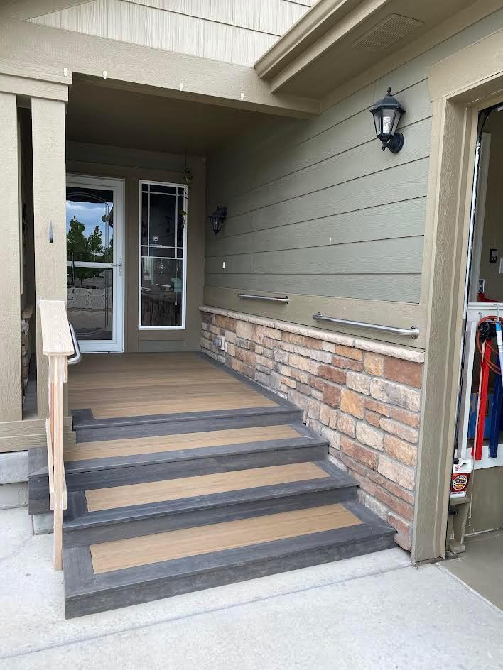 Trex composite deck stairs built by AFGH Handyman over existing concrete steps beside a stone wall
